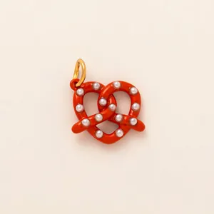 Detail of red pretzel charm with white pearls and gold ring for bags and keys