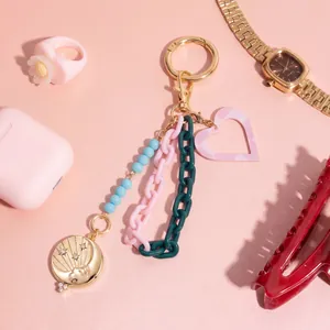 Fashionable keychain pendant with colorful chains, blue beads, and a gold celestial charm