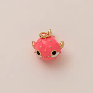 Détail d'un porte-clés poisson-globe rose avec finitions dorées et détails en émail