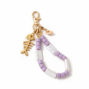 Detailed shot of lavender bead keychain with golden fishbone and natural seashell