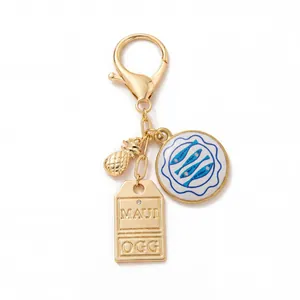 Detail van Maui OGG sleutelhanger met gouden ananas en vispatroon emaille hanger