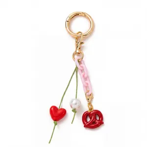 Porte-clés à anneau doré avec chaîne rose et breloque en forme de bretzel rouge