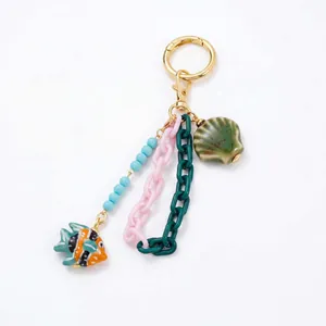 Detail van DIY oceaan-sleutelhanger met tropische vis, acryl ketting en een schelp