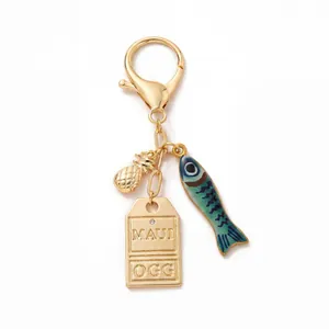 Gouden sleutelhanger met ananas, emaille vis en gegraveerd Maui OGG metalen label