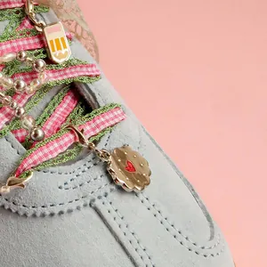 DIY sneaker charm set with pink plaid laces, pearl chain, and cookie metal pendants