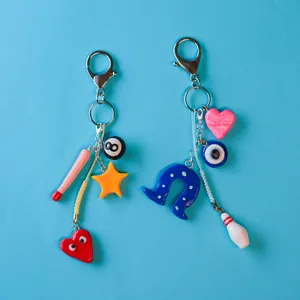 Detalle de originales colgantes para bolso con bola de billar, ojo turco y estrellas