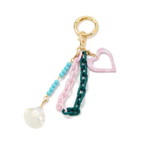 Detail of colorful acrylic chain keychain with shell pendant and pink heart charm