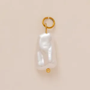 Macro view of baroque rectangular pearl pendant with golden loop and natural luster