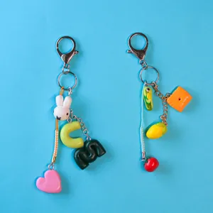 Colgantes creativos para bolsos con bonitos dijes de conejo, limón y galleta en fondo azul