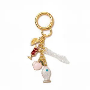 Détail du porte-clés doré 18K avec pendentifs citron, pêche, boisson et perles