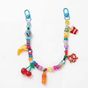 Detail van kleurrijke Y2K kralenbedels met minifruit en frisdrankfles hangers
