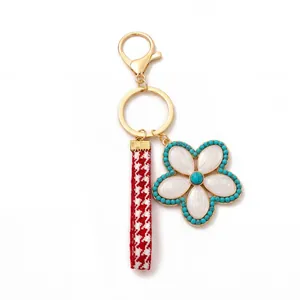 Detail of floral keychain with red houndstooth ribbon and turquoise beaded flower pendant