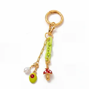 Detail van 18K goud vergulde sleutelhanger met groene ketting en paddenstoel