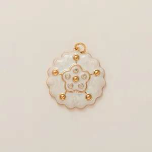 Detailed view of a gold floral charm with white enamel and sparkling center zircons