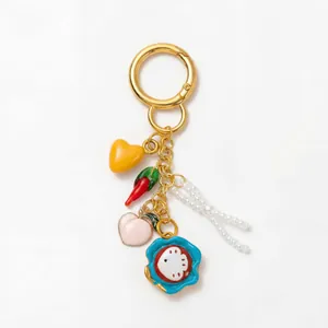 Détails d'un porte-clés doré 18 carats avec breloques colorées et pampilles en perles
