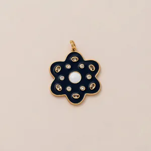 Detailed close-up of a vintage black enamel flower keychain with gold-plated petals