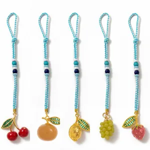 Handmade woven fruit keychains with vibrant cherry, orange and strawberry pendant designs