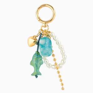 Golden keychain with koi fish bead, white pearls, and blue marble resin rectangle