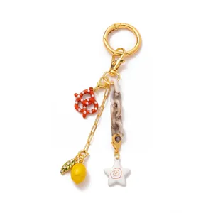 Detail of 18K gold plated keychain with enamel pretzel, lemon and marble acrylic chain