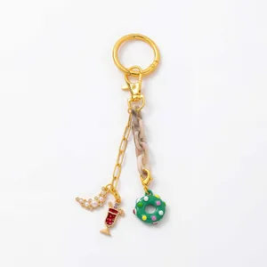 Detail of 18K gold-plated keychain with marble acrylic chain and creative cocktail charms