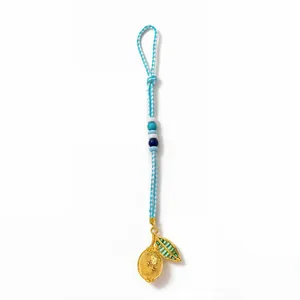 Handmade woven keychain with blue beads and a golden textured lemon charm on white background