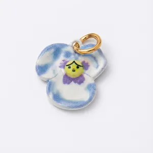 Macro view of pansy-shaped ceramic pendant with 18K gold ring and artistic blue glaze