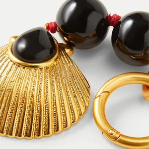 Luxuriöse Halskette mit goldenem Muschel-Anhänger, schwarzen Perlen und roter Kordel