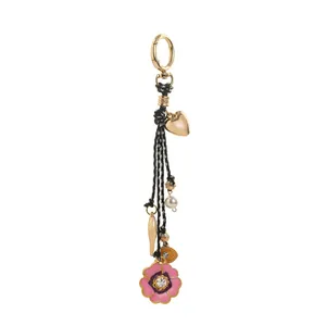Detail of a floral bag charm with heart, pearl and crystal-set pink flower pendant