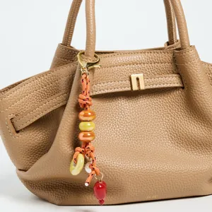 Brown litchi leather handbag with colorful ceramic beaded star pendant and gold hardware