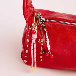 Red gathered leather shoulder bag with cherry dice charms and pearl beaded accessories