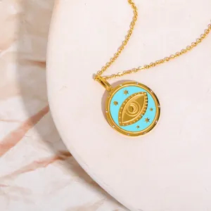 Detailed close-up of 18K gold tarot pendant with blue enamel eye and star motifs