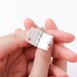 Macro view of a stainless steel book locket with heart cutout and mechanical opening mechanism