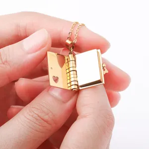 Detail of gold book-shaped pendant with heart cutout and openable photo frame structure