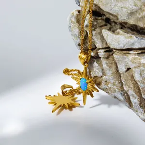 Dettaglio della collana a stella dorata con opale blu su sfondo di pietra naturale grezza