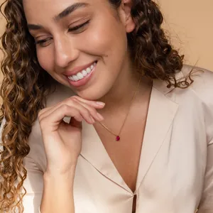 Pear cut red zircon birthstone necklace in 18k gold plating worn by a model