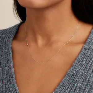 Elegant gold initial A pendant necklace on a delicate chain worn by a female model