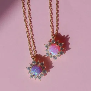 Exquisite gold sunflower necklace with pink opal and zircon pavé on pink background