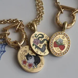 Detail van vintage gouden hangers met aardbeien, parels en glanzende strasstenen