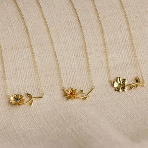 Primer plano de collares de flores doradas con gemas azules, magenta y verde esmeralda