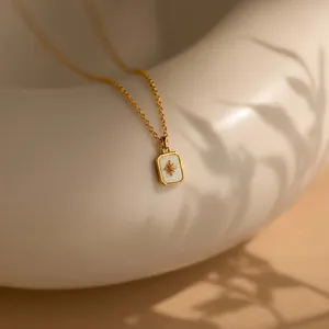 Detail der Goldstern-Halskette mit weißem Opal-Inlay auf einer Keramikschale