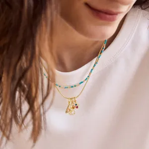 Layered gold snake chain and turquoise bead necklace with sparkling number 15 pendant