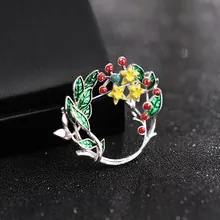 Macro shot of wreath brooch with green enamel leaves and yellow zircon sunflower details