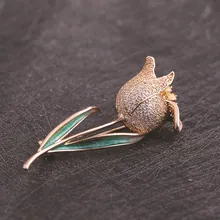 Detail of rose gold tulip brooch with micro-pave crystals and green enamel leaf