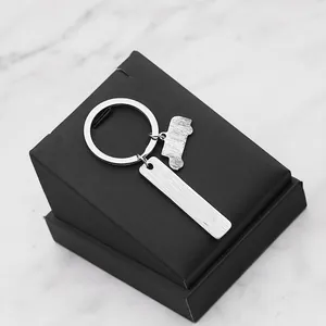 Vue macro du porte-clés en métal brossé avec pendentif voiture sur boîte cadeau noire