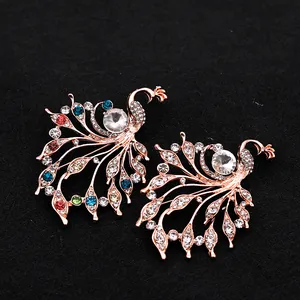 Broches paon exquises avec strass colorés sur un fond en tissu texturé noir