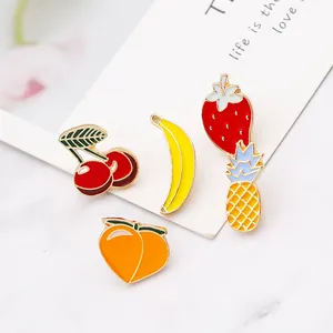 Set di spille smaltate a forma di frutta con ciliegia banana e fragola su marmo
