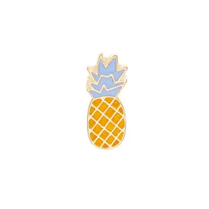 Dettaglio di una spilla a forma di ananas con foglie in smalto blu e corpo giallo
