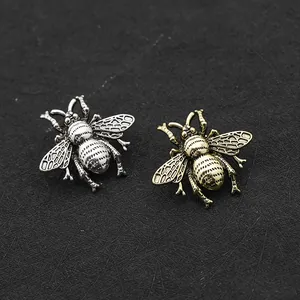 Macro-opname van realistische bijenbroches in goud en zilver met fijne vleugeldetails
