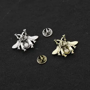 Detail van vintage bijenbroches in brons- en zilverlegering met vlindersluiting achterkant