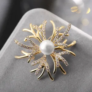 Elegant gold flower brooch with central pearl and sparkling zircon crystal accents
